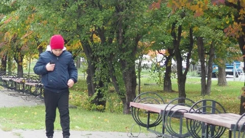 Boy using smartphone in park.  school  boy in casual wear talking on the phone 库存影片 164472240