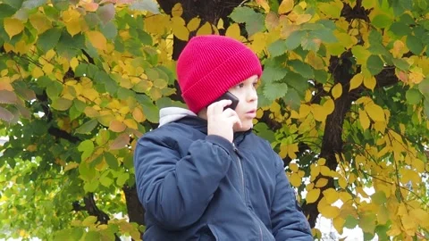 Boy using smartphone in park.  school  boy in casual wear talking on the phone Stockbeeldmateriaal 164472389