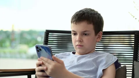 Boy using smartphone preteen child concentration serious expression screen time Vídeo Stock 336822810