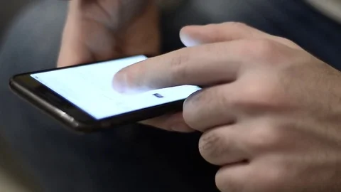 Boy using a smartphone to shop online from home in Milan, Italy Stock Footage 76104671