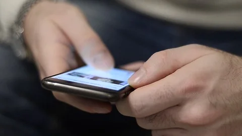 Boy using a smartphone to shop online from home in Milan, Italy Stock Footage 76105504