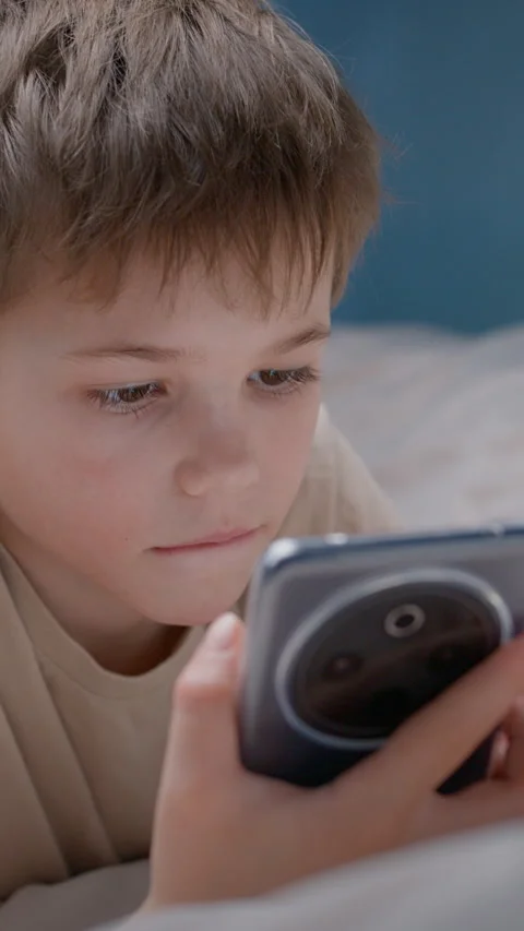Boy using smartphone while lying on bed at home Stock Footage 326640723