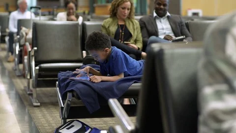 Boy using a tablet at an airport 動画素材 77078508