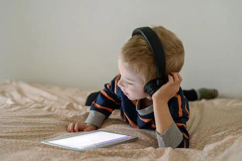 Boy using tablet on bed Stock Photos