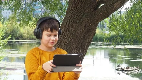 Boy using tablet computer, teenager relaxing in the park Video stock 270936841