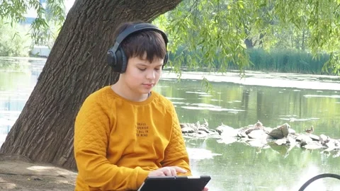 Boy using tablet computer, teenager relaxing in the park Video stock 270936843
