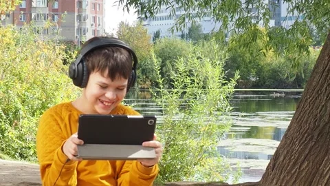 Boy using tablet computer, teenager relaxing in the park Video stock 270936872