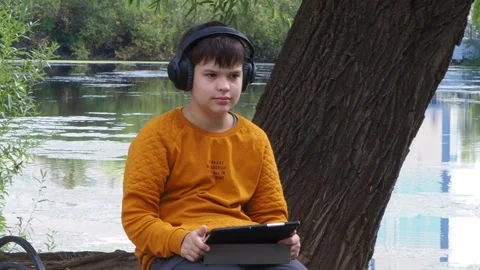 Boy using tablet computer, teenager relaxing in the park Video stock 270936977