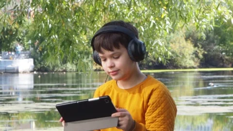 Boy using tablet computer, teenager relaxing in the park Video stock 270937080