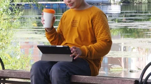 Boy using tablet computer, teenager relaxing in the park Stock Footage 270937140