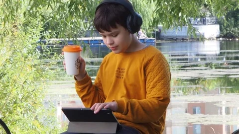 Boy using tablet computer, teenager relaxing in the park Stock Footage 270937160
