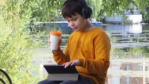 Boy using tablet computer, teenager relaxing in the park Stock Footage 270937165