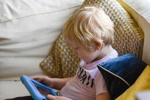 Boy using a tablet device with learning app at home Stock Photos