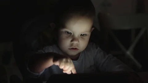 Boy using tablet in evening in dark Stock Footage 70786050