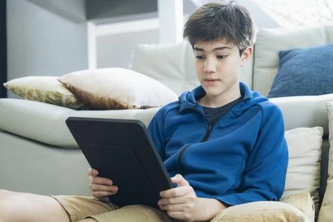 The boy using tablet at home. Stock Photos