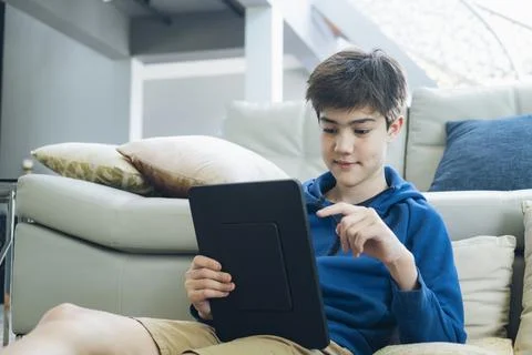 The boy using tablet at home. Stock Photos