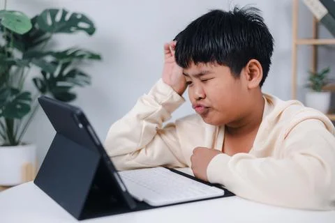 Boy using tablet for learning and stressed about online learning, Virtual i.. Stock Photos