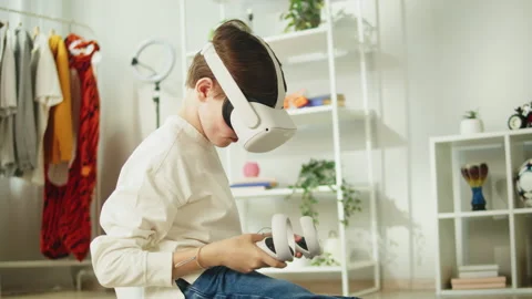 Boy using virtual reality glasses with controllers, playing video games, child Stock Footage 204797038
