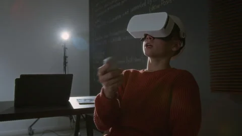 Boy Using VR Headset and Controller while Developing Computer Code 動画素材 318717139