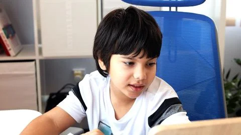 Boy utilizing technology for online education seated near table He participating Stock Photos