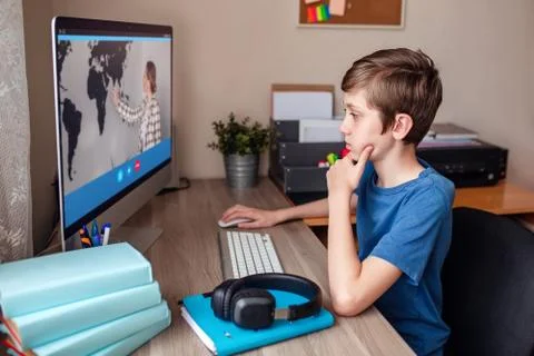 Boy video conferences with a tutor on the computer at home. The concept of Stock Photos