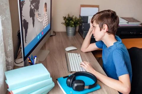Boy video conferences with a tutor on the computer at home. The concept of Stock Photos