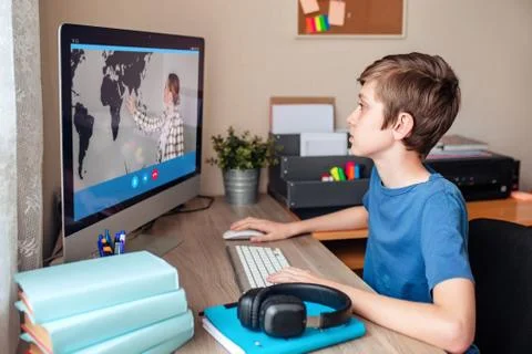 Boy video conferences with a tutor on the computer at home. The concept of Stock Photos