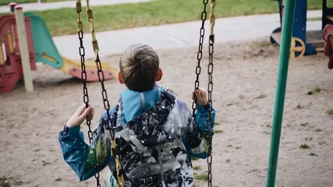The boy vigorously swings on the swing. The camera follows his movements Stock Footage 116395685
