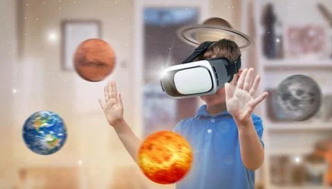 Boy with a virtual reality headset exploring planets in his room. The concept Stock Photos