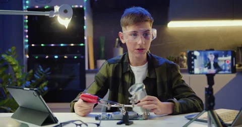 Boy vlogger makes online streaming using smartphone is studying electronics and 動画素材 239026912
