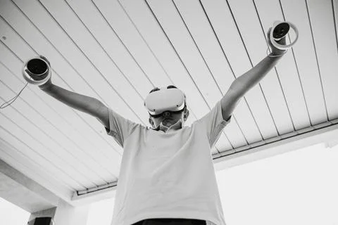 Boy in VR glasses with controllers in hands Stock Photos