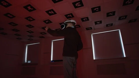 Boy in vr headset is shooting from a bow in a big room with flickering trendy Stock Footage 125912128