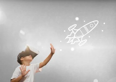 Boy in VR headset touching space illustrations against grey background with Stock Photos