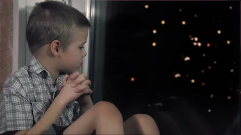 Boy waiting for the miracle of the window late at night Stock Footage 58016629