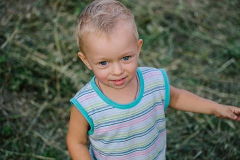 A boy is walking along a clearing in the grass Stock Photos
