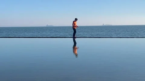 Boy walking along a ledge with water either side Stock Footage 149596236