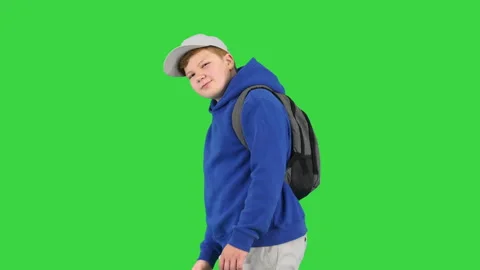 Boy walking by and making hello gesture to camera on a Green Screen, Chroma Key. Stock Footage 147139056