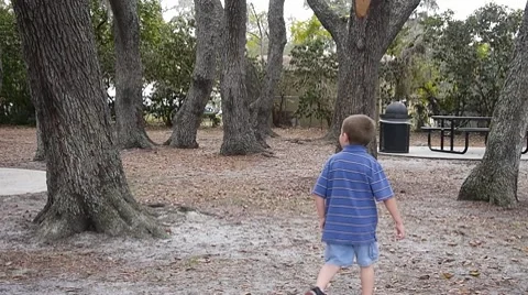 Boy walking around park Stock Footage 10737317