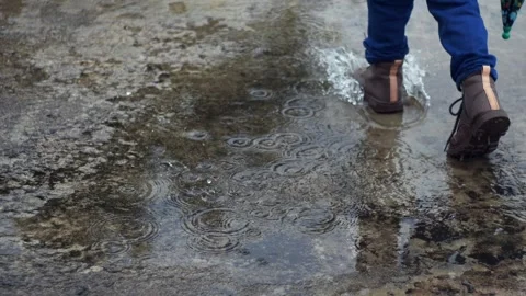 Boy Walking Away Through Rain Puddle Stock Footage 309539955