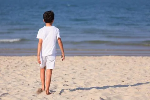 Boy walking on beach Stock Photos