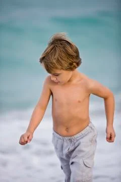 Boy walking on the beach Stock Photos