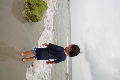 A boy walking on the beach Stock Photos