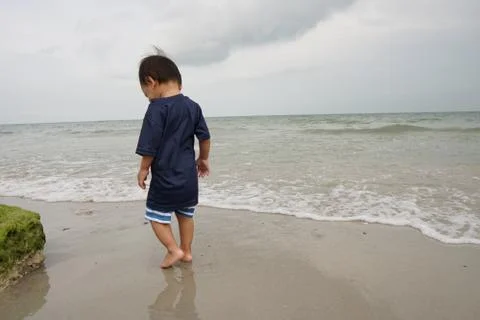 A boy walking on the beach Stock-Fotos