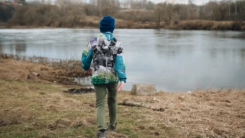 The boy is walking in the direction of the river Bank Stock Footage 128016529