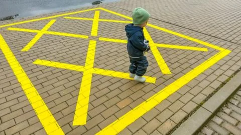 Boy walking on empty parking lot or space on the urban street in the city Stock Photos