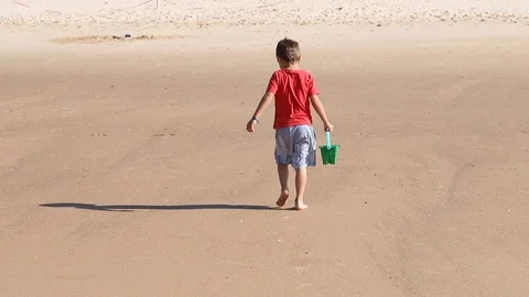 Boy walking with green bucket in beach Stock-Footage 116725656