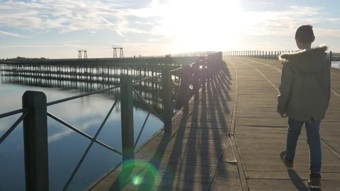 A boy walking by the pier Video stock 83840256