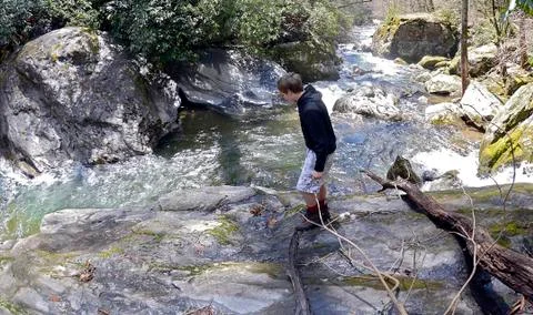 Boy walking at the river Stock Photos