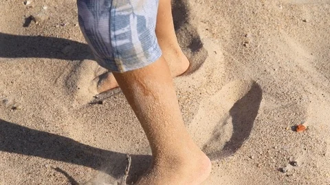 Boy walking in sand on the beach Stock Footage 116725783