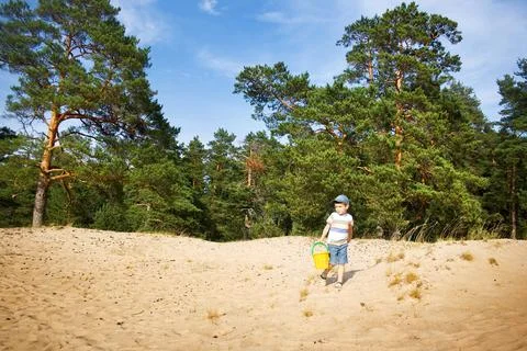 Boy walking on the sand Stock Photos